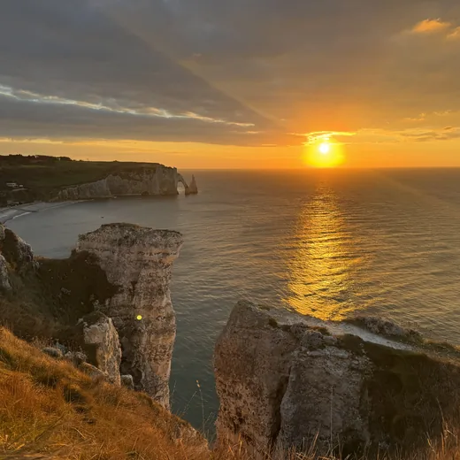 Sunset over sea cliffs, an expansive golden-hour view